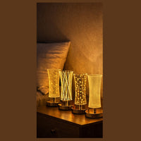 Four decorative lamps on a bedside table with a warm glow.