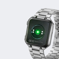 Silver smartwatch with a green display on a light gray background